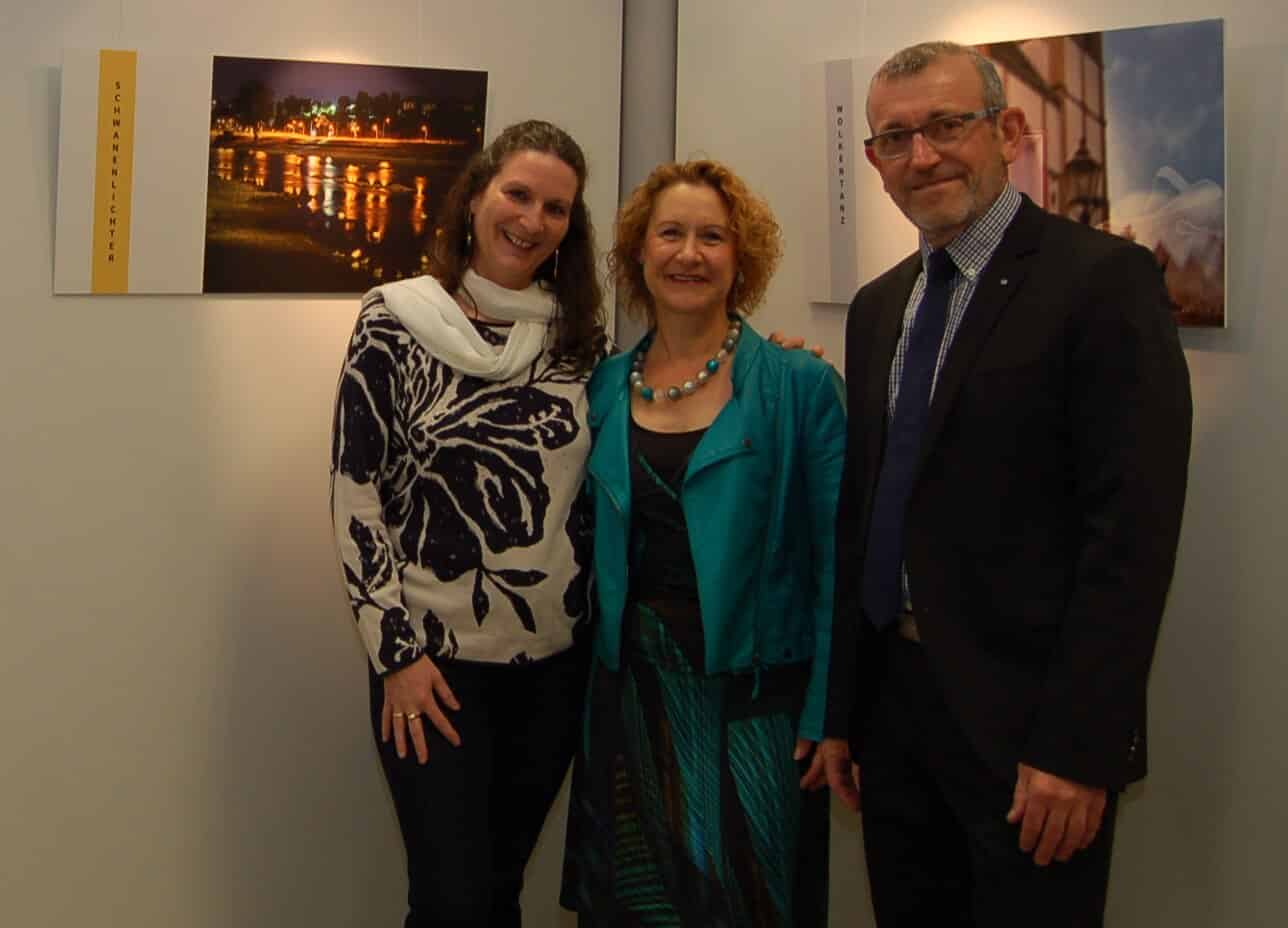Das Foto zeigt die Künstlerinnen Vera Wolber (Bildmitte) und Sabine Schunk-Heller zusammen mit Reinhard Schmitz, dem Leiter der Sparkassen-Filiale Schlossstraße.