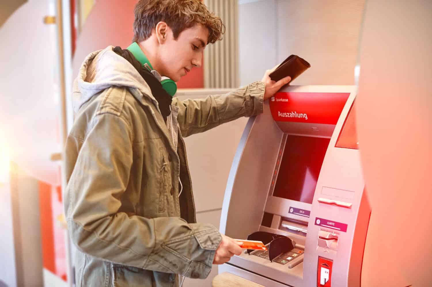 Junger Mann am Geldautomaten