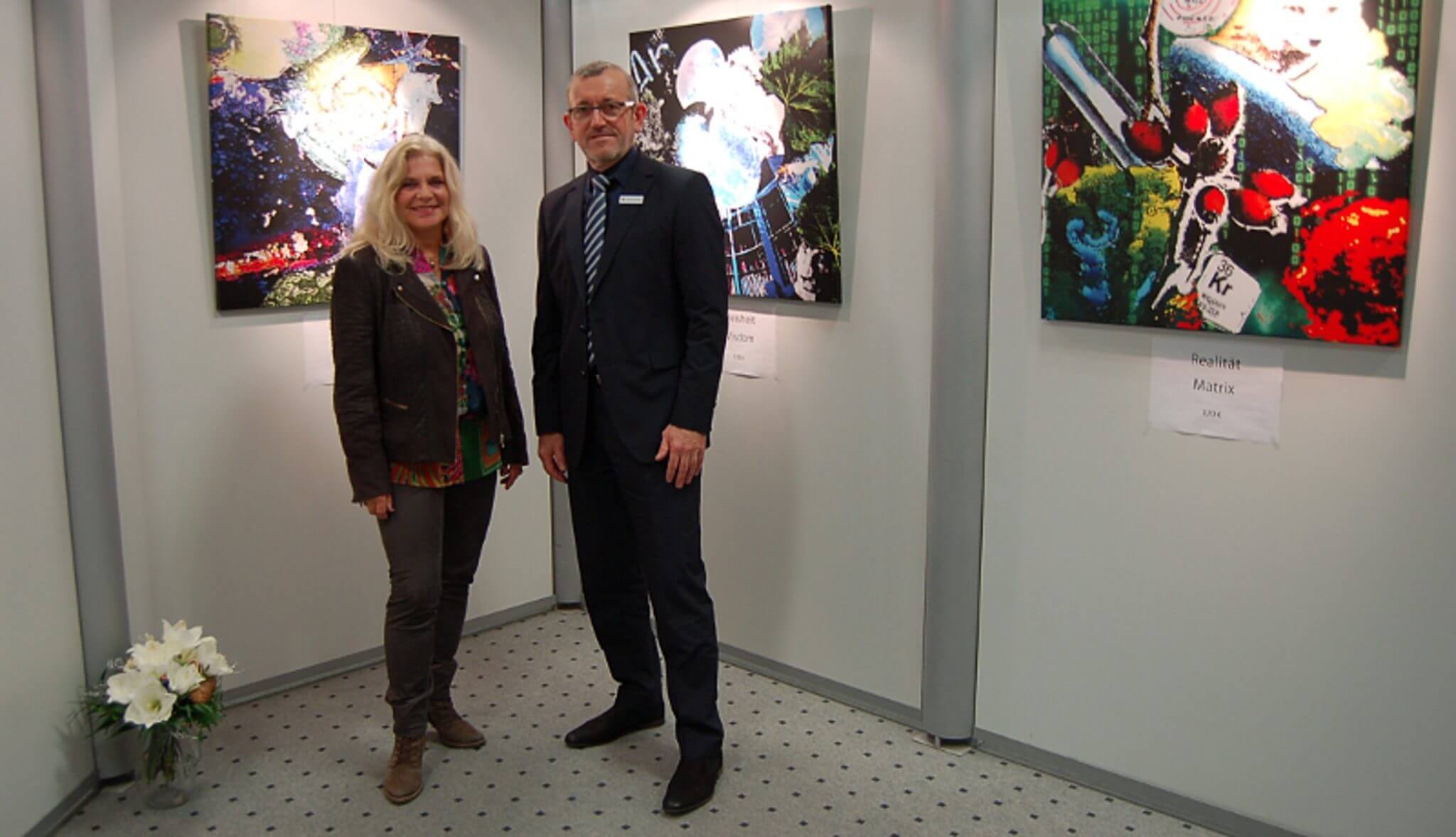 Das Foto zeigt Uta Ewerhardy zusammen mit Reinhard Schmitz, dem Leiter der Filiale Schlossstraße, anlässlich der Ausstellungseröffnung Anfang Januar 2019.