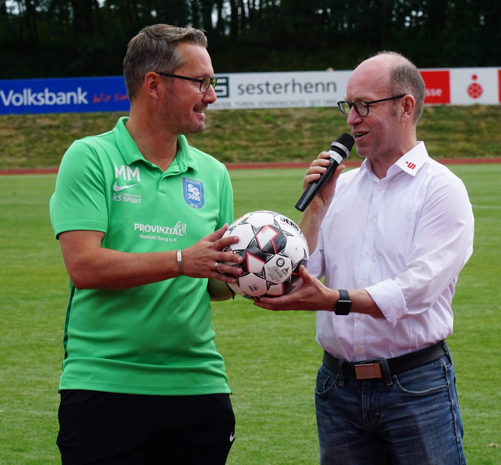 Bernd Oster überreichte dem Trainer der SG 2000, Michel Maur exemplarisch einen Spielball für die neue Saison.