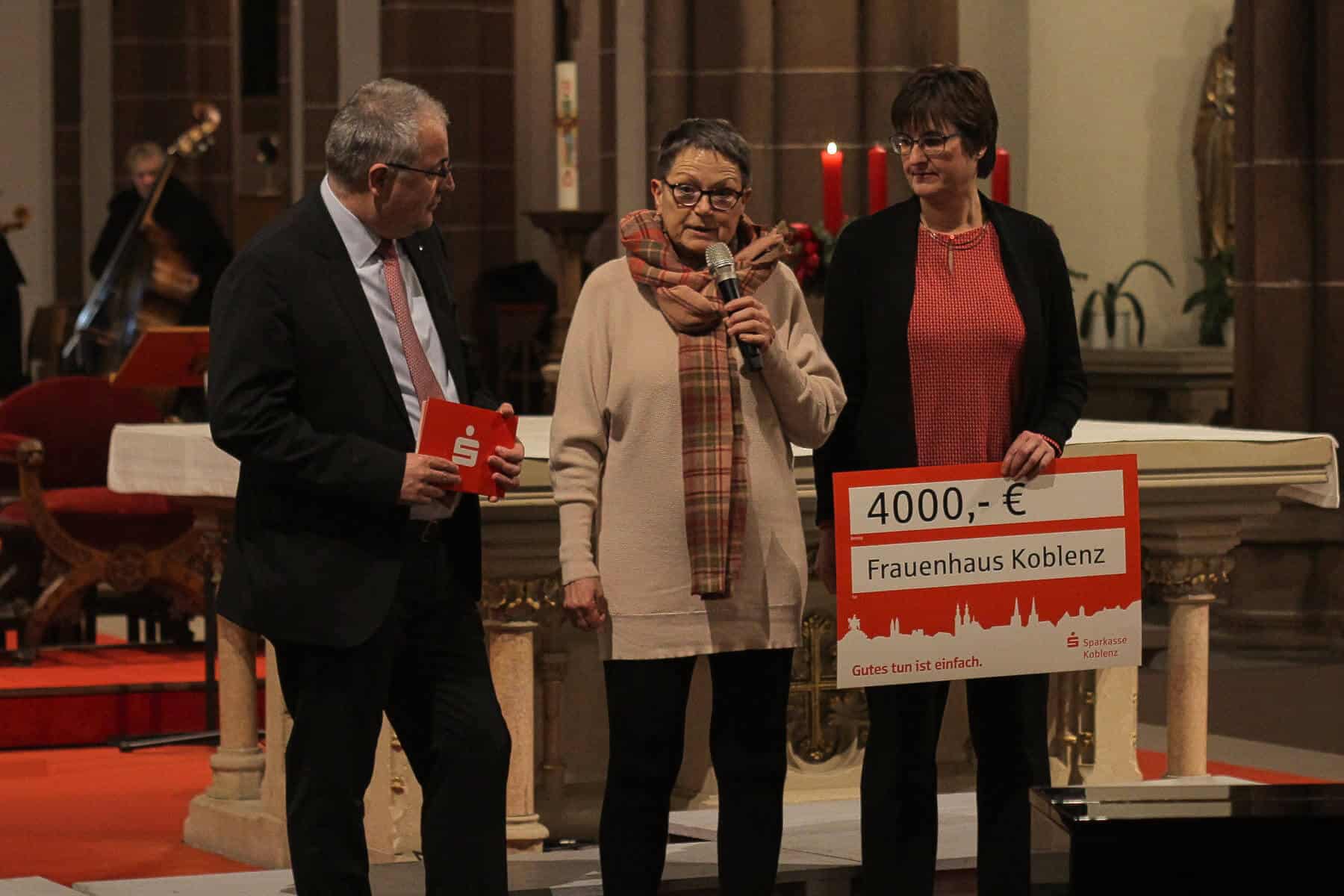 „Spendenscheckübergabe“: Jörg Perscheid (links) übergibt den symbolischen Spendenscheck von 4.000 Euro an Nora Salvadori (Mitte) und Alexandra Neisius (rechts).