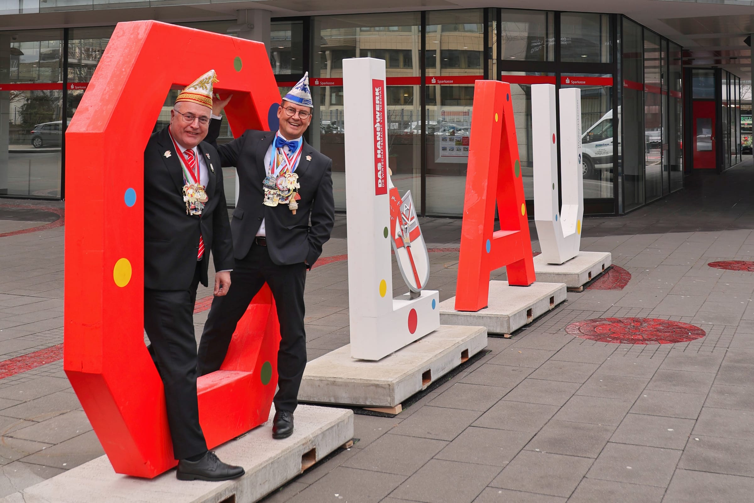 Der Vorstand der Sparkasse Koblenz, Jörg Perscheid (links) und Matthias Nester (rechts), präsentieren den „Olau“-Schriftzug vor der Hauptgeschäftsstelle in der Bahnhofstraße in Koblenz. Foto: Dieter Lösch