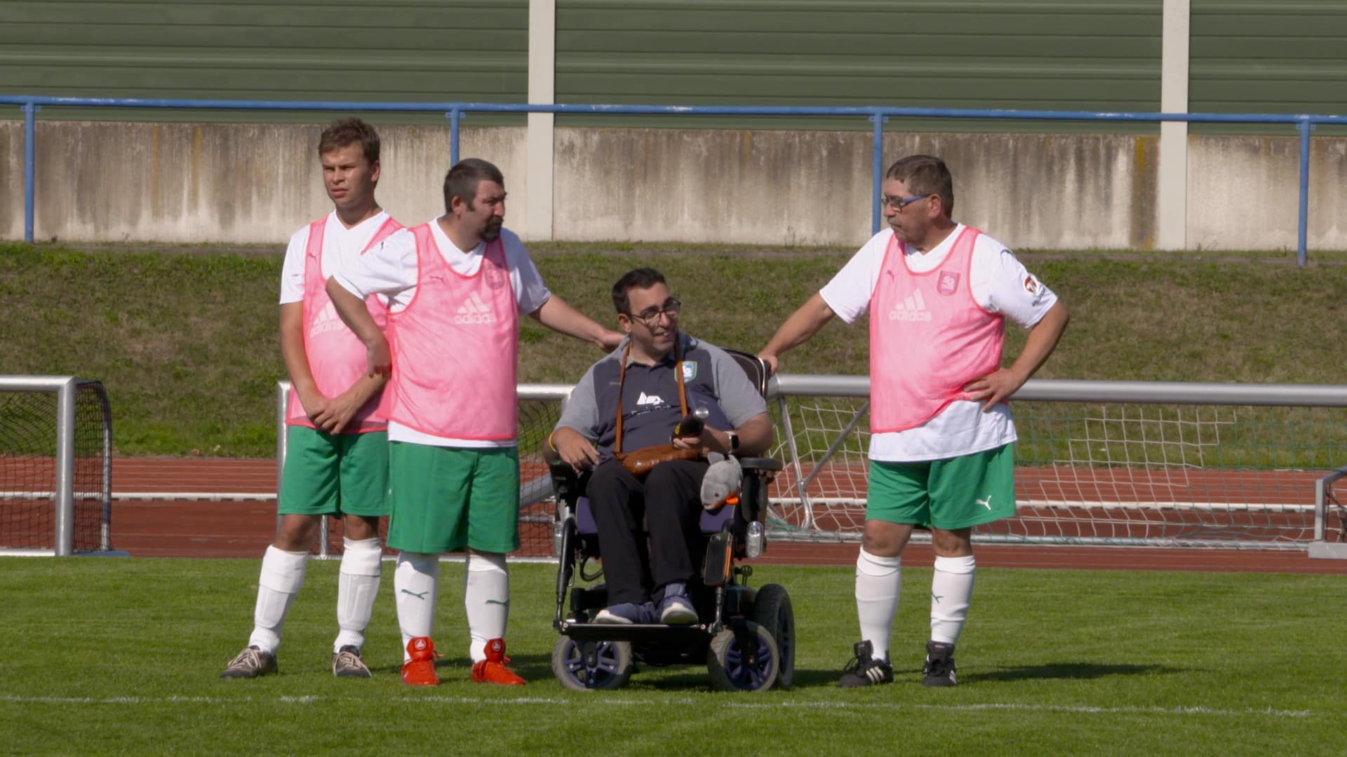 Stefan Zeidan, Inklusionsbeauftragter der SG 2000 Mülheim-Kärlich (Mann im Rollstuhl) im Gespräch mit Fußballspielern